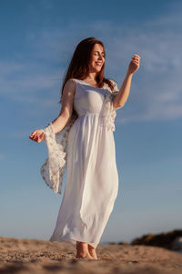 Full length of woman on beach against sky