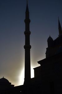 Low angle view of silhouette buildings against sky