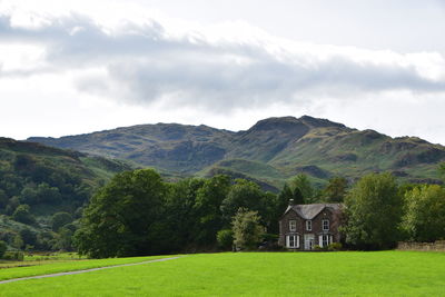 Scenic view of green landscape and mountains against sky