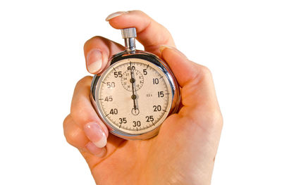 Close-up of hand holding clock against white background