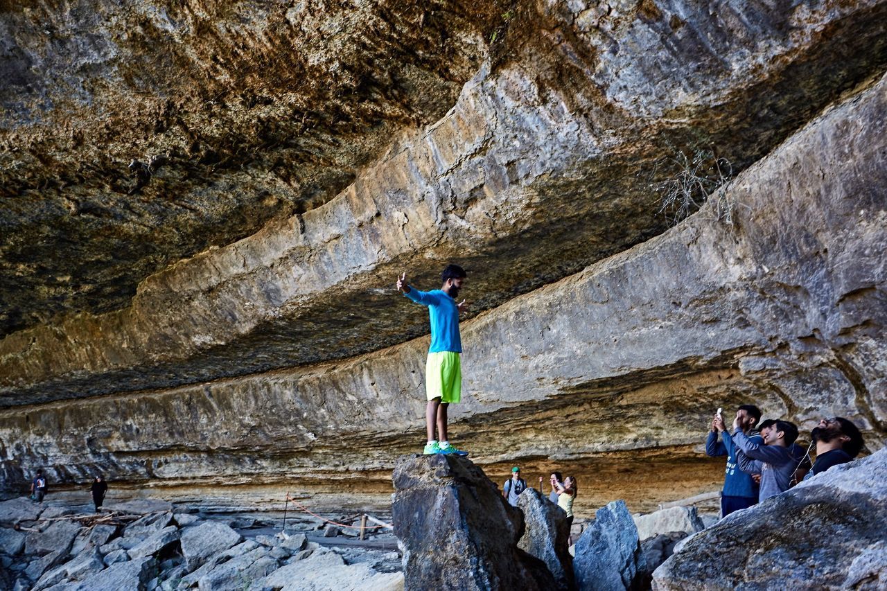 lifestyles, leisure activity, rock - object, full length, rock formation, men, water, person, casual clothing, high angle view, vacations, adventure, rock, standing, rear view, cliff, tourist, boys