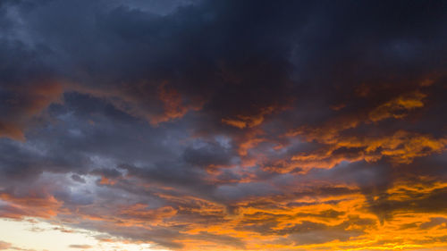 Low angle view of storm clouds in sky during sunset