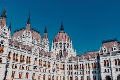 Low angle view of buildings against clear blue sky