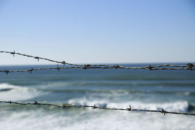Close-up of barbed wire against clear sky
