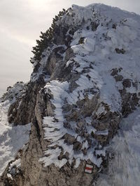 Scenic view of snow covered rock against sky