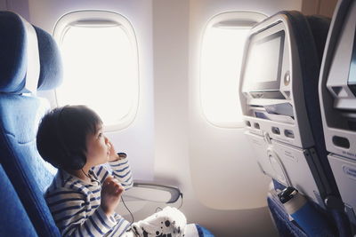 Side view of boy sitting in airplane