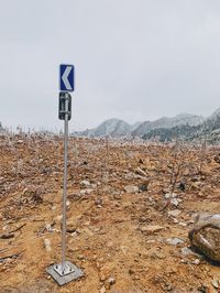 Information sign on road against sky