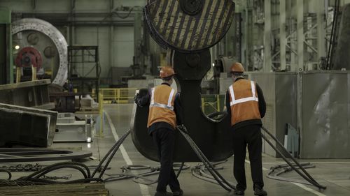Rear view of man standing in factory