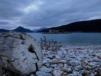 Scenic view of lake by snowcapped mountains against sky