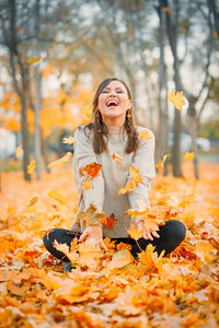 Portrait of young woman standing amidst plants