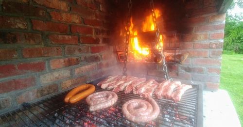 Campfire on barbecue grill against brick wall