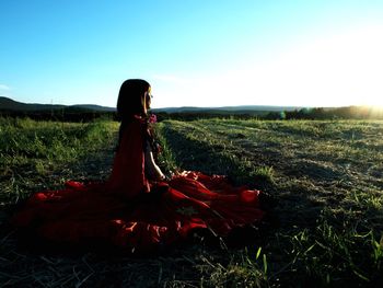 Woman on field against sky during sunset