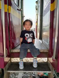 Portrait of cute boy sitting on train