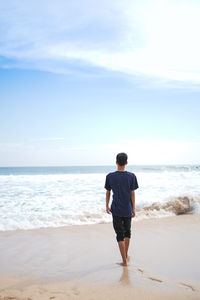 Rear view of man standing on beach