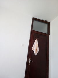 Close-up of white door with text on wall