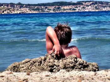 People relaxing on rocks at beach