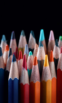 Close-up of colored pencils against black background
