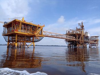 Low angle view of abandoned pier on sea against sky