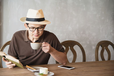 Man holding coffee cup on table