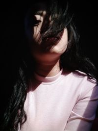 Close-up portrait of a woman against black background