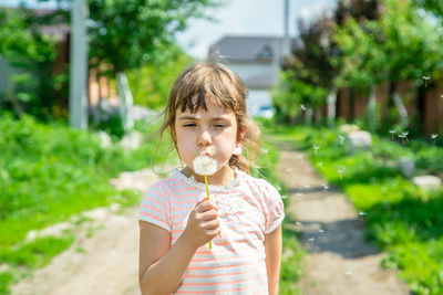 Cute girl blowing dandelion seed