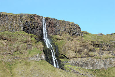 Scenic view of waterfall against clear sky