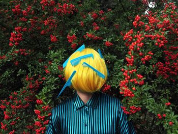 Rear view of person standing on yellow flowering plants