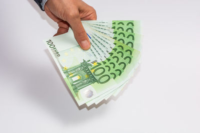 Midsection of person holding paper against white background