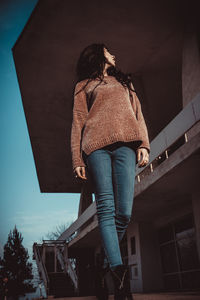 Low angle view of woman standing against building