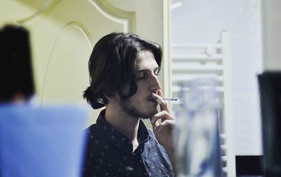 Man smoking cigarette at home