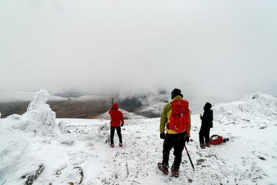 Tourists on snow covered mountain