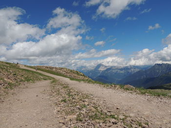 Road leading towards mountains against sky