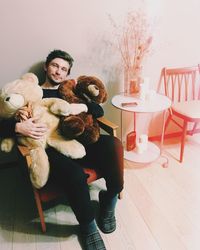 Portrait of man with toy sitting on table