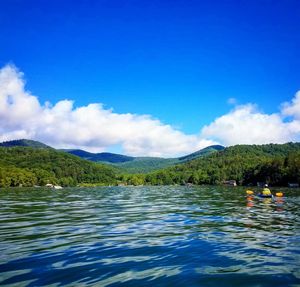 Scenic view of lake and mountains against blue sky