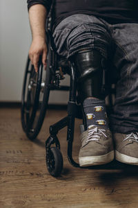 Low section of man standing on wheelchair