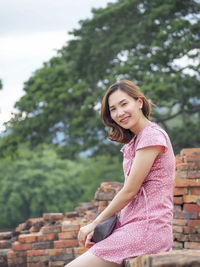 Portrait of a smiling young woman sitting outdoors