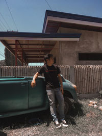 Full length of man leaning against vintage car