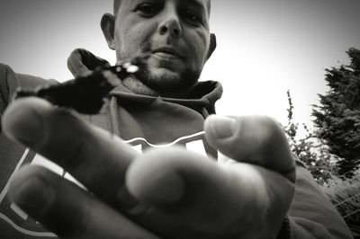 Low angle view of young woman standing on tree trunk