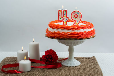 Close-up of red cake with candles on table