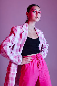 Young woman standing against gray background