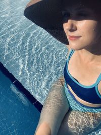 Midsection of woman wearing hat in swimming pool