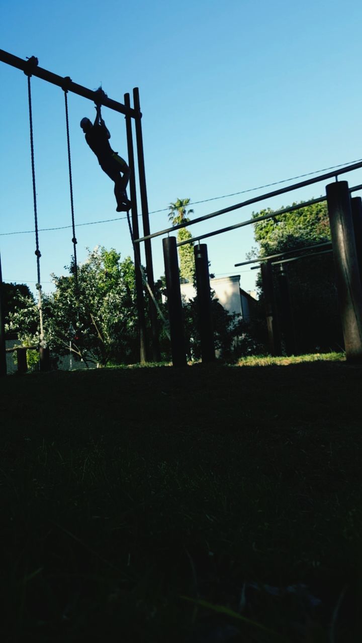 clear sky, built structure, blue, architecture, low angle view, sky, building exterior, sunlight, copy space, field, fuel and power generation, tree, electricity pylon, power line, outdoors, fence, metal, day, no people, house