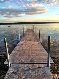 View of jetty over water against cloudy sky