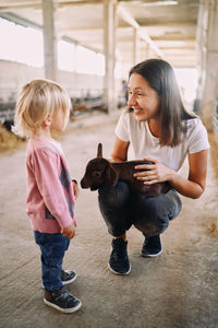 Side view of young woman with dogs at home