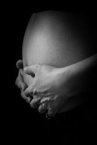 Close-up of woman hand against black background