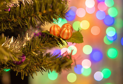 Closeup of balls on christmas tree. bokeh garlands in background. new year concept.