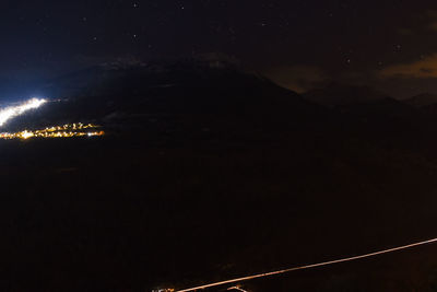 Aerial view of illuminated mountain against sky at night