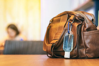 Close-up of purse with sanitizer bottle on table 