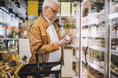 Senior man analyzing container at grocery store