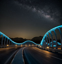 Light trails on road against sky at night